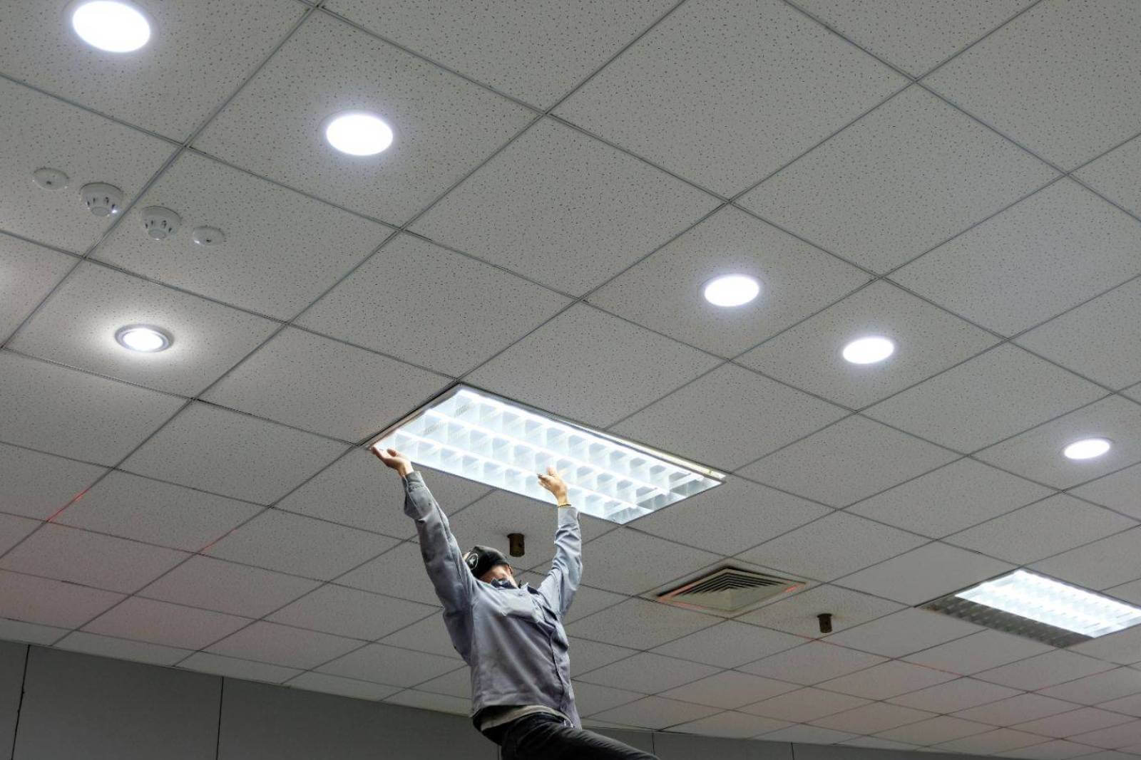 ACS worker installing light fixture
